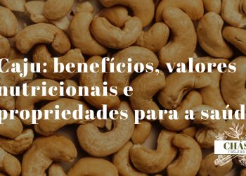 benefícios do caju — castanhas de caju cruas em formato de rim sobre fundo rústico de madeira