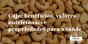 benefícios do caju — castanhas de caju cruas em formato de rim sobre fundo rústico de madeira