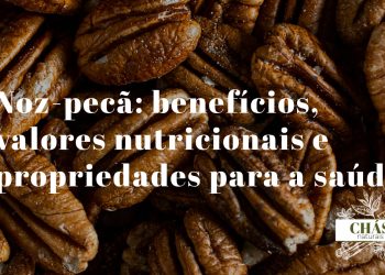 benefícios da noz-pecã — metades de noz-pecã com textura rugosa castanha sobre fundo escuro rústico